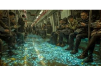 地铁车厢灯光昏黄，那列车像个不知疲倦的巨兽在城市地下穿梭,在拥挤的人流当中